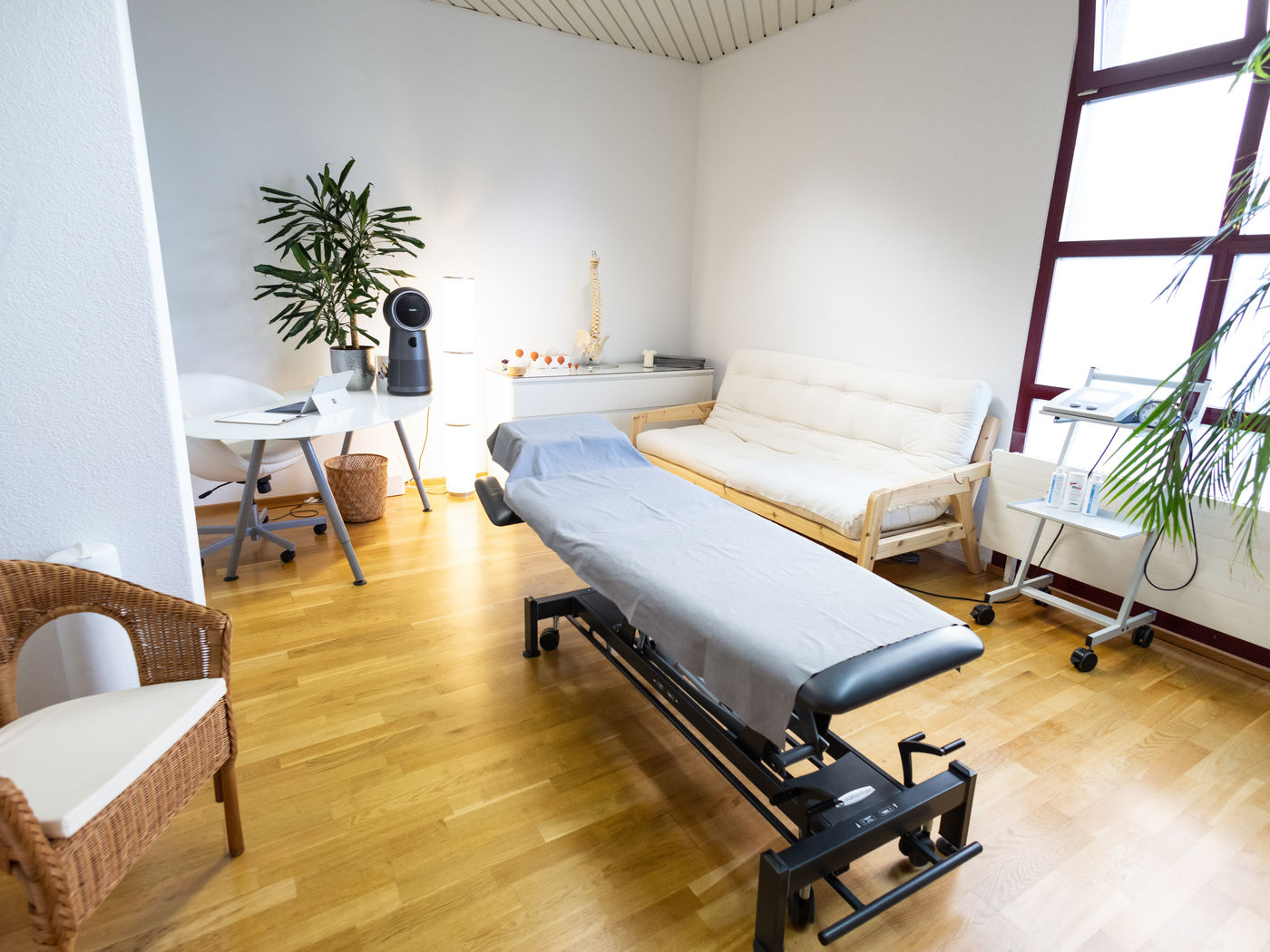 Helles Behandlungszimmer mit Therapieliege